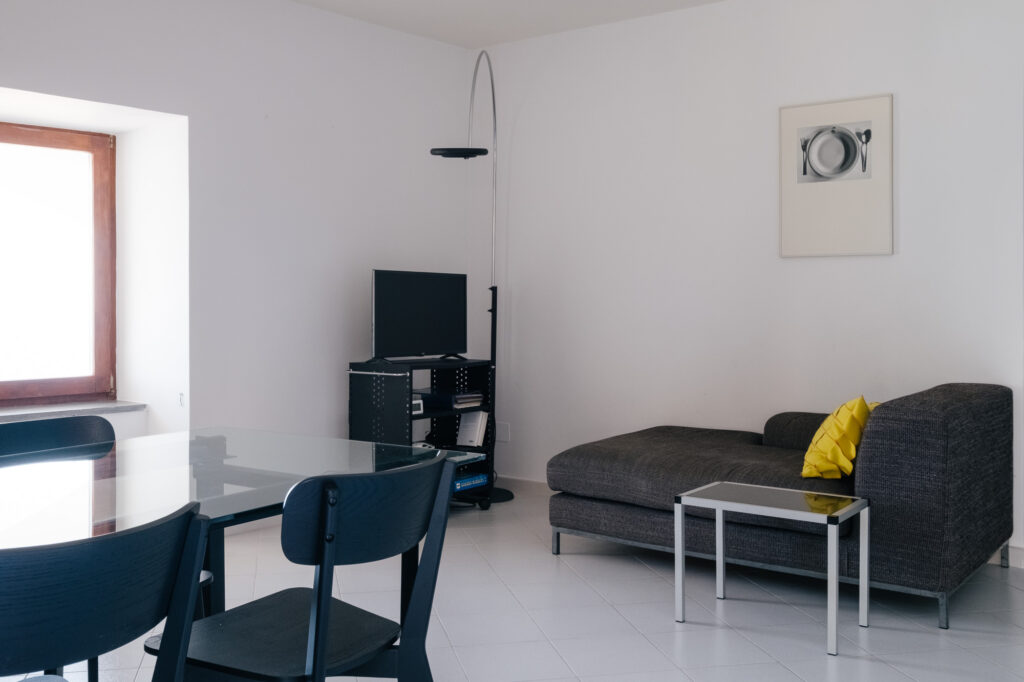 Wohnbereich mit Sofa, Esstisch und Fernseher