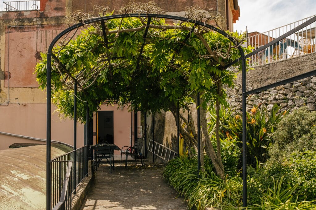 Pergola verde con zona pranzo davanti all’appartamento